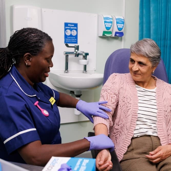 Nurse preparing to draw blood from the patient.