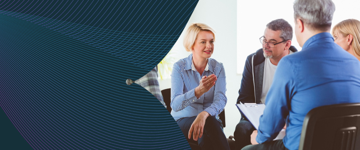 Blond mature woman sharing issues during meeting.