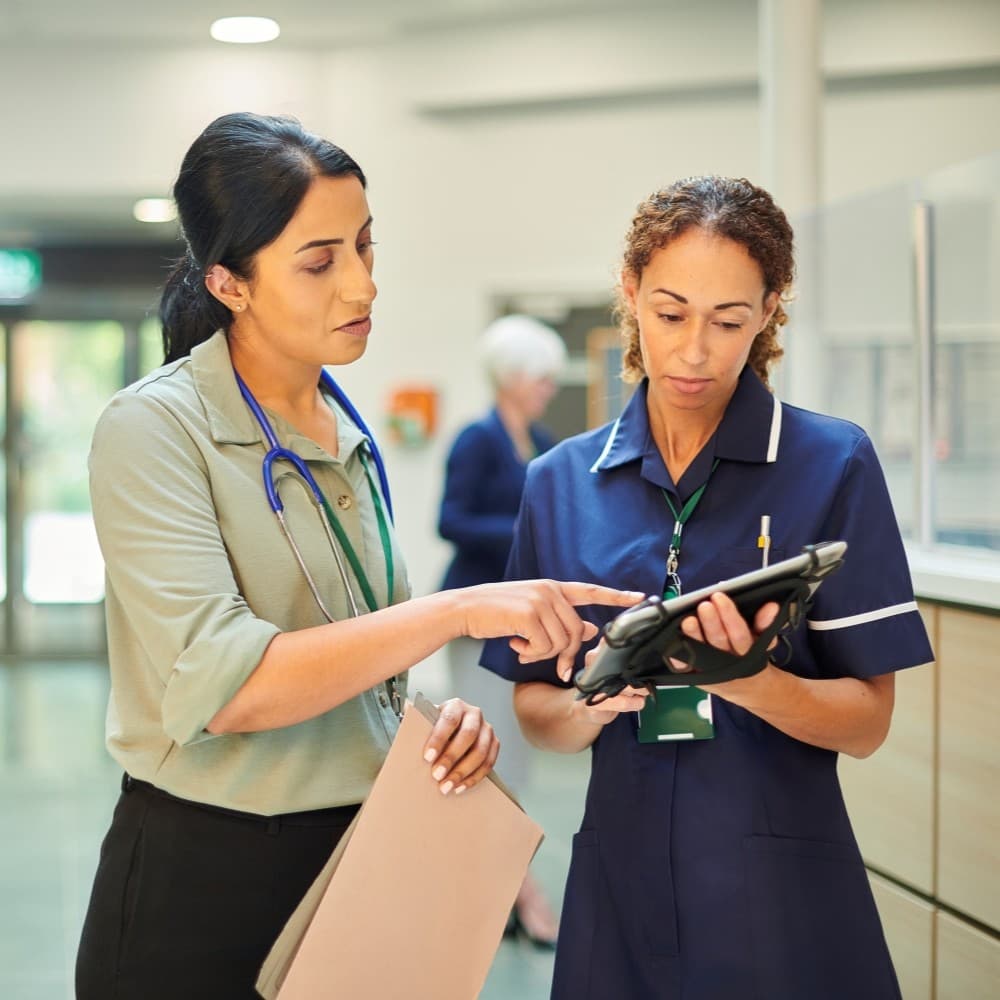 Two medical professionals having a discussion in a hospital corridor.